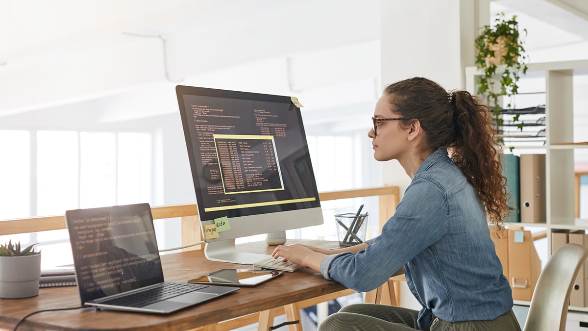Woman working on a desktop computer with multiple platforms